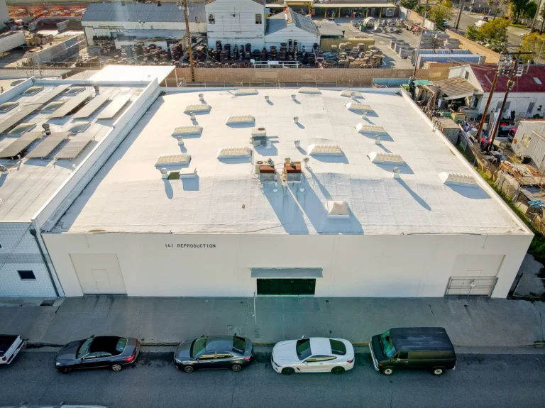 Large white warehouse building with rooftop units seen from above